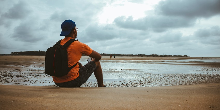 An image showing Tajpur Beach with gentle waves meeting the shoreline under a clear sky.