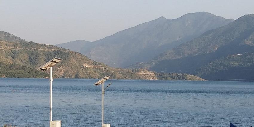 A picturesque view of Tehri Lake with adventure activities like boating and jet skiing