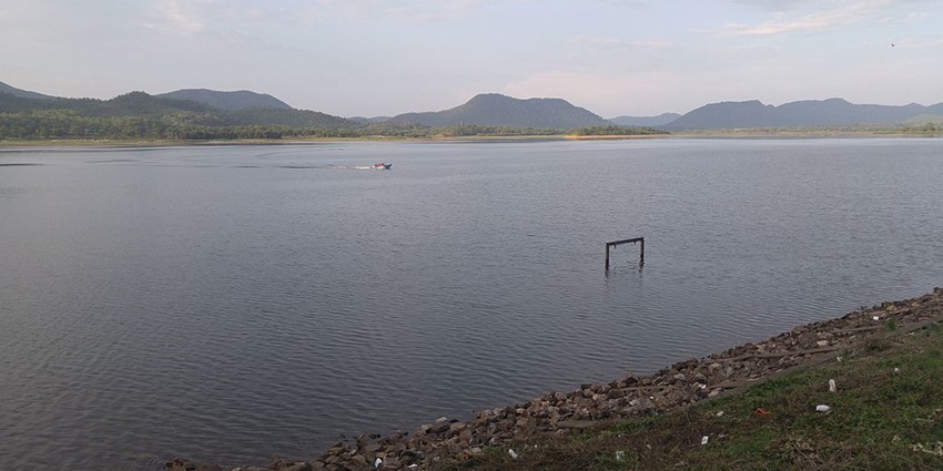Lake in Jamshedpur with a large still water body, rocky shorelines and a motorboat