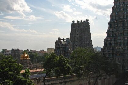 Multiple gopurams of temples with detailed carvings and vibrant, colourful architecture