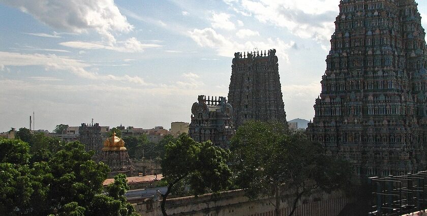 Multiple gopurams of temples with detailed carvings and vibrant, colourful architecture