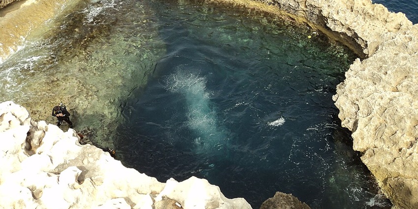 A natural underwater sinkhole with deep, clear waters and an abundance of marine species.