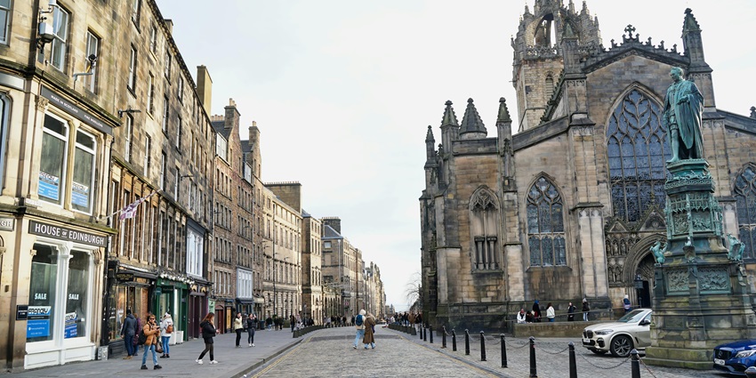 Historic street with medieval charm, street performers, and unique shops in Scotland.