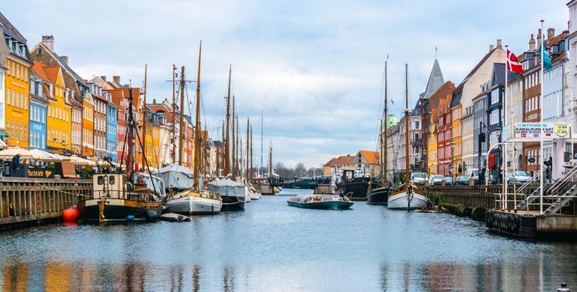 An image showing a view of boats in canal in Denmark during day time things to do in Copenhagen