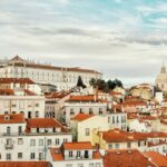 A Lisbon cityscape with red-tiled roofs and buildings, showcasing the charm of Portugal