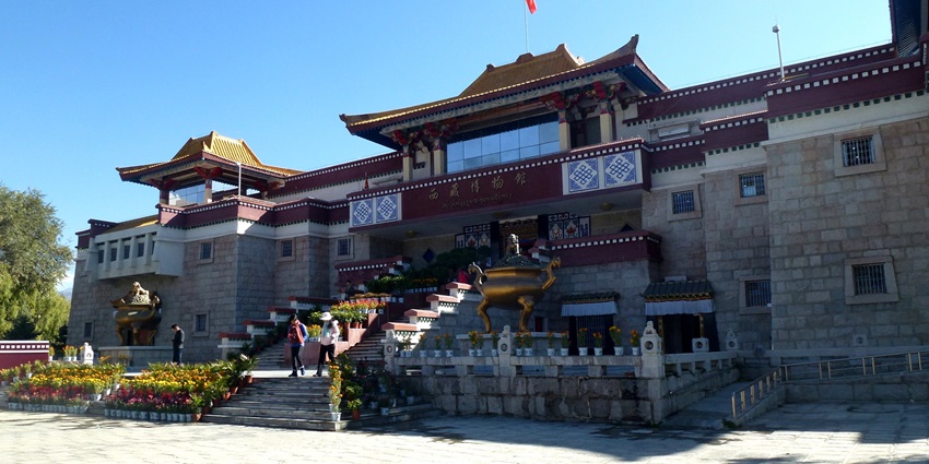 An image of a museum interior with chairs and paintings, similar to the Tibet Museum, Dharamshala