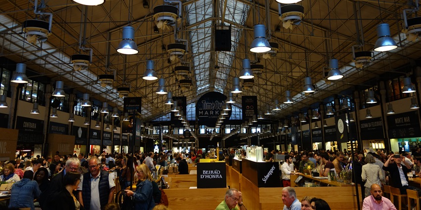 People enjoy their food at a crowd-packed Time Out Market in Lisboa or Lisbon, Portugal.