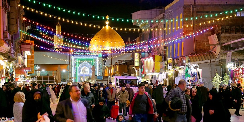 Tourists roaming around in a street beside the Imam Ali Mosque.