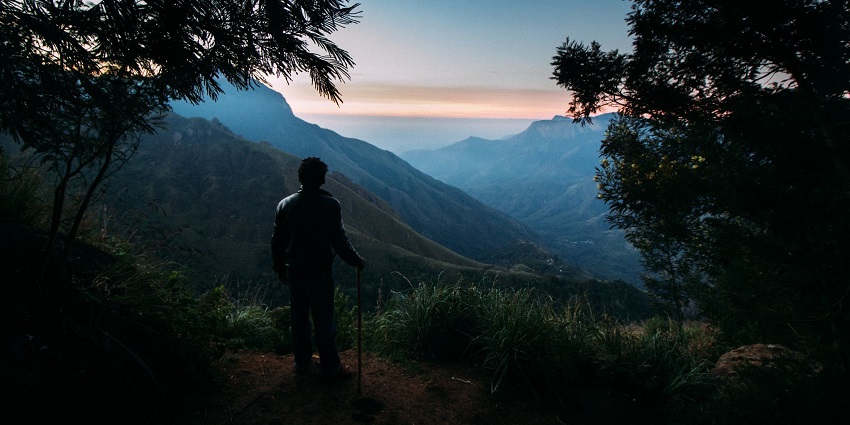 The silhouette of a man enjoying a pre-sunrise moment from a viewpoint in Top Station near Munnar.