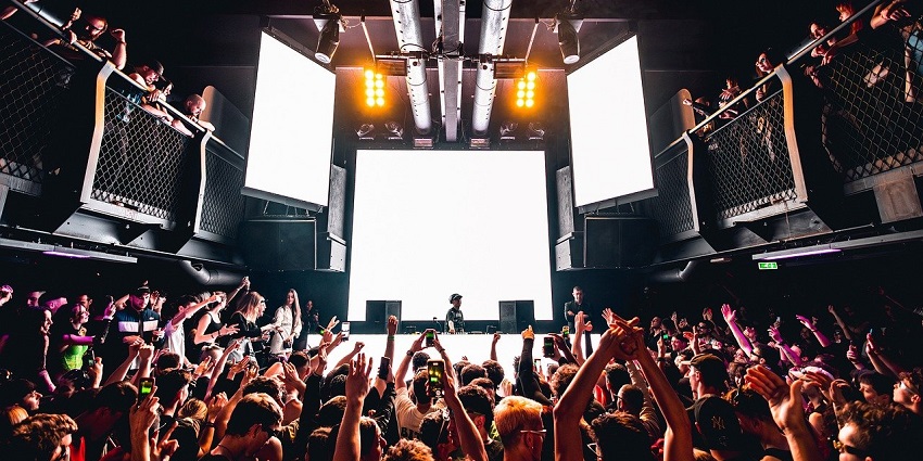 An image showing a woman DJ performing at a nightclub, reflecting Trädgården's lively vibe.