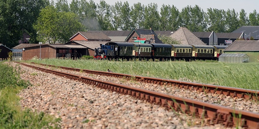 Vintage steam tram ride through charming Dutch towns and countryside.