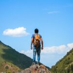 A man standing on the top of the hills while trekking in Aravali Hills in Gurgaon