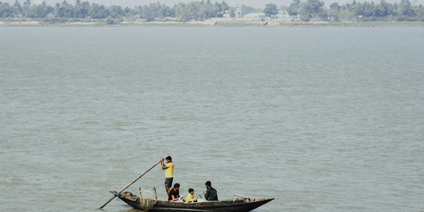 An image of a boatman rowing a boat to the trekking point of Gandikota