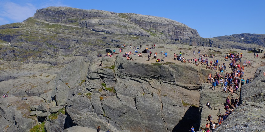 An image showing tourists in line to stand on Trolltunga, capturing the essence of trekking in Norway