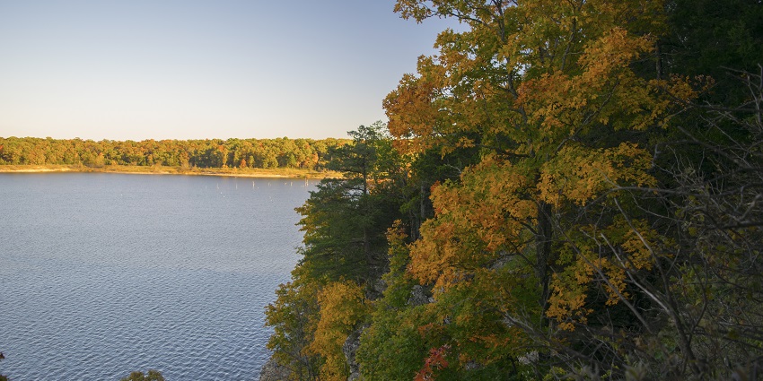 Calm Truman Lake, surrounded by the autumn leaf trees at Truman Lake State Park.