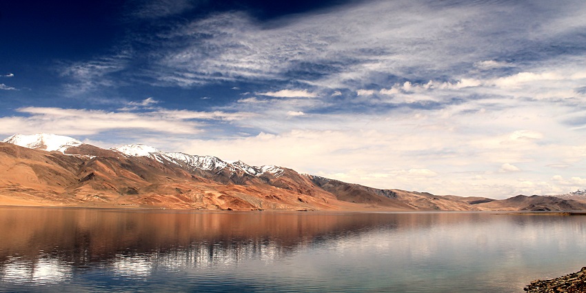 An awe-inspiring view of Tso Moriri Lake with its crystal-clear waters and surrounded by rugged mountains in Ladakh.