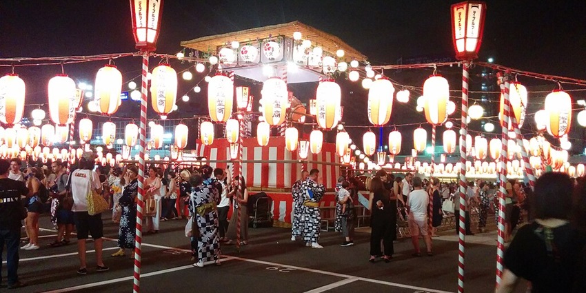 A lively night scene at Tsukiji Outer Market, filled with seafood stalls and street food