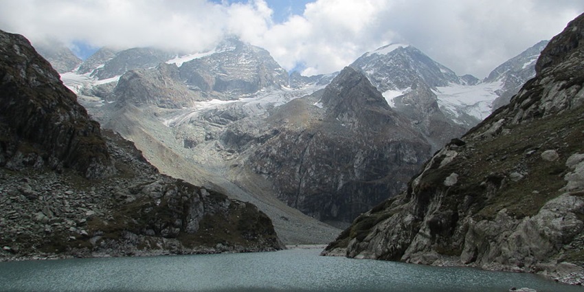 Tullian Lake surrounded by rocky shorelines and mountains with peaks covered in snow