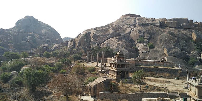 Chitradurga Fort with old architecture, stairs, multiple pillars and a rocky mountain.