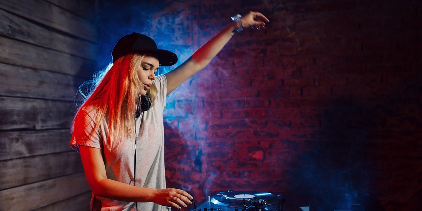 An image showing a woman DJ performing at a lively nightclub, setting the atmosphere.