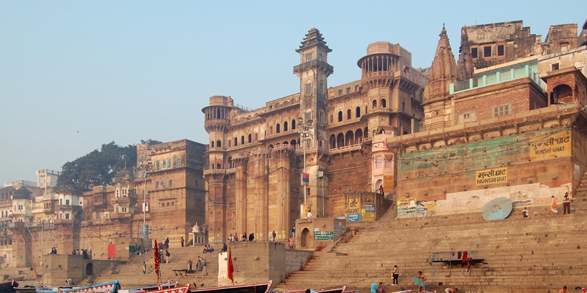 An image of Varanasi showcasing the Ghats along the Ganges River, with boats and temple structures