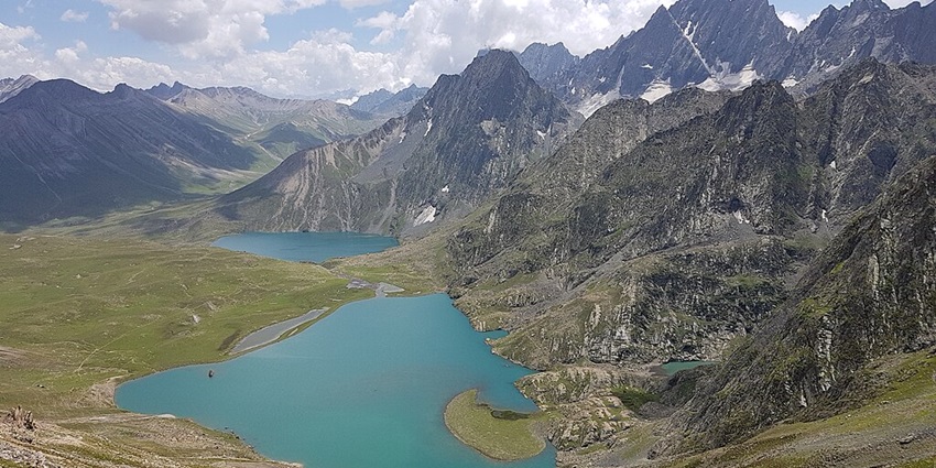 Vishansar Lake with Kishansar Lake next to it, surrounded by mountains under a clouded sky