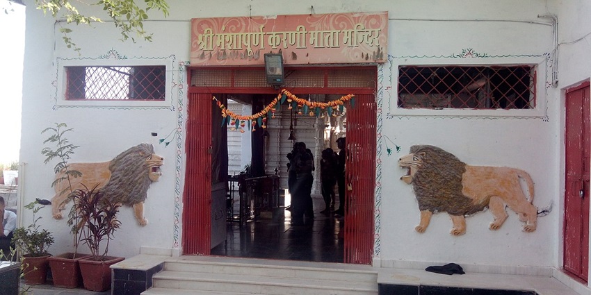 The entrance of Karni Mata Temple is adorned with carvings of lions and vibrant decorations