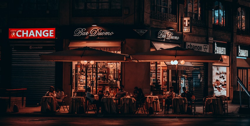 Group of people sitting outside of cafes - Visiting late night eateries is a must do activity