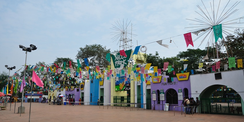 The Nicco Park entrance has vibrant and colourful decorations and trees in the background