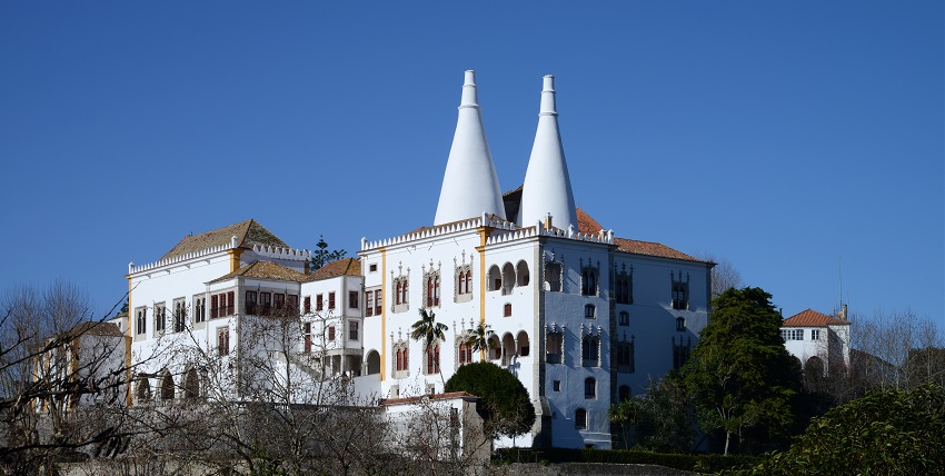 The National Palace of Sintra Portugal with its iconic conical chimneys against a blue sky