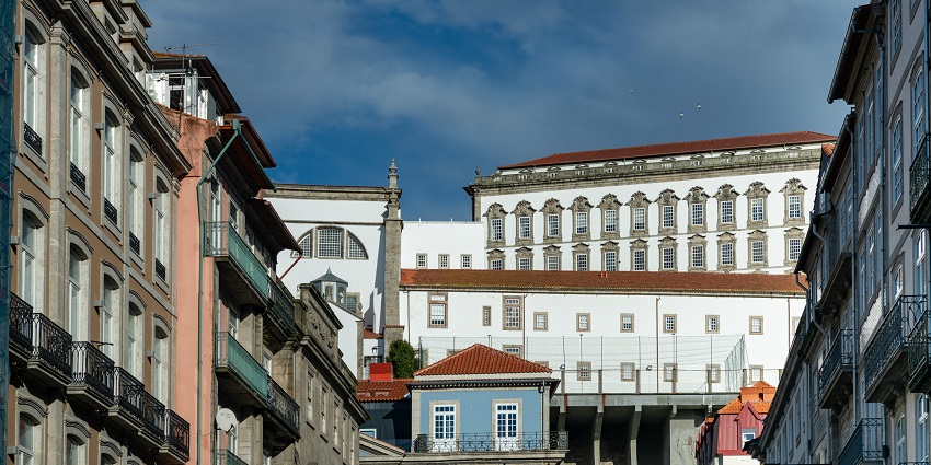 Street view in Porto, Portugal, featuring historic buildings and the Episcopal Palace.