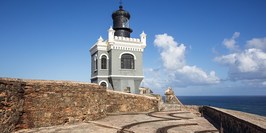 El Morro lighthouse atop the fortress in San Juan, Puerto Rico, against a blue sky.