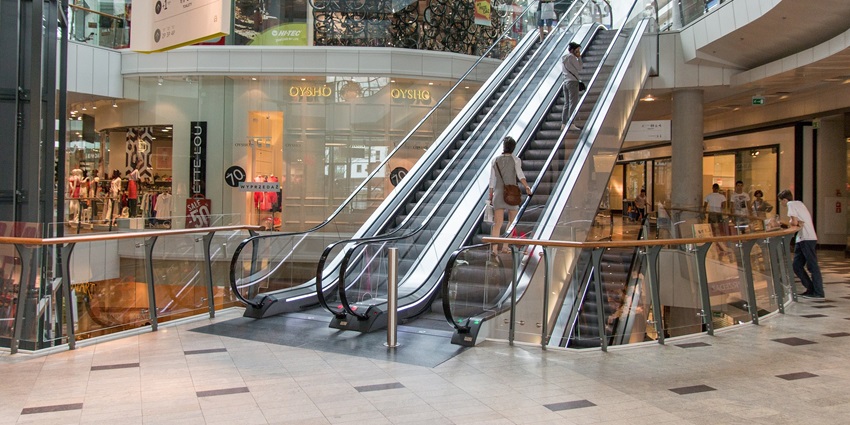 An image of a modern shopping mall with escalators and various stores, one of the best shopping malls in London England.