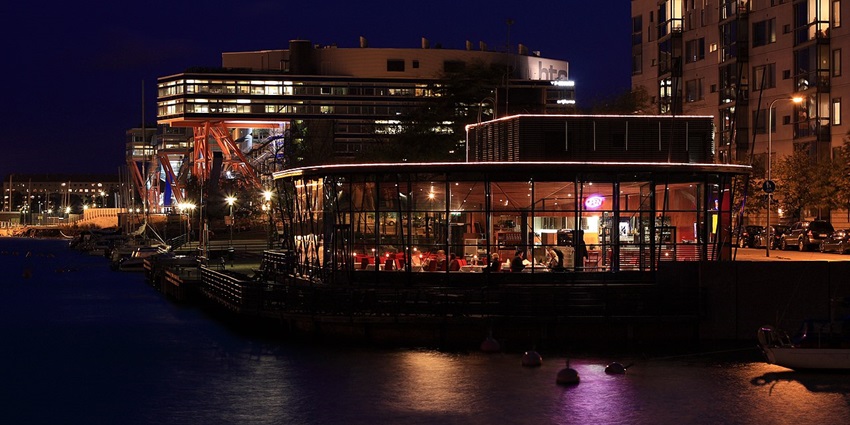 Night view of a restaurant in Finland filled with customers enjoying their food.