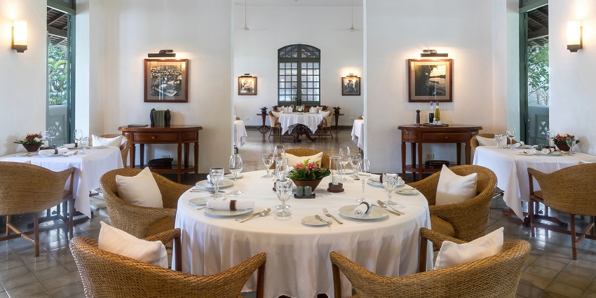 A Panoramic view of the dining hall of a restaurant with white and wooden decor.