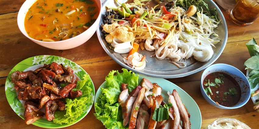 Image of types of dishes with noodles, meat, soup and also veggies served on a table