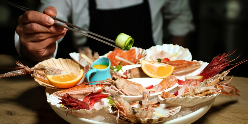 A dish filled with various seafood, including shrimp, mussels, and other shellfish