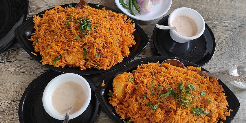 Traditional Khasi cuisine served on a steel plate in a restaurant.