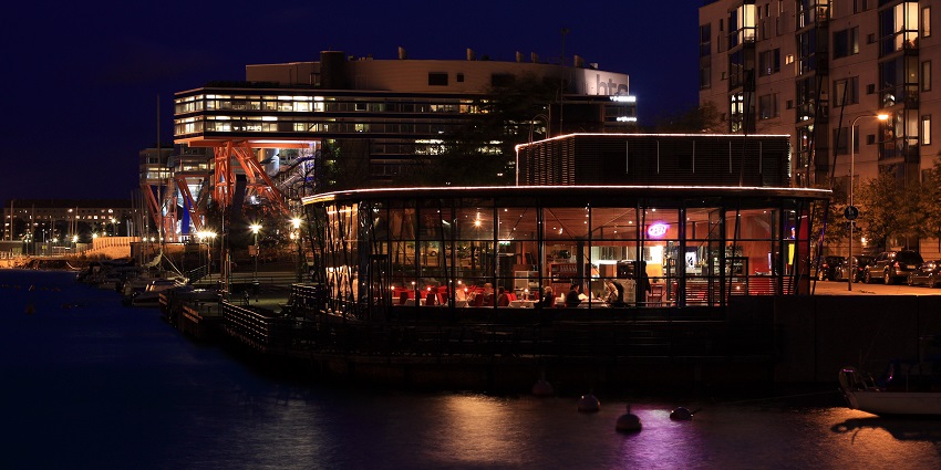 Night view of a restaurant in Finland filled with customers enjoying their food.
