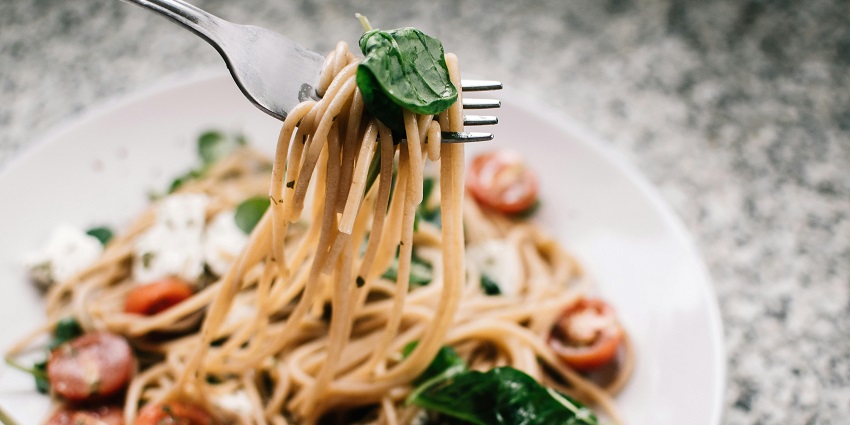 Image of the cooked noodles and the fork being served in the plate in a Restaurant