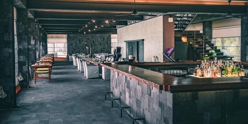 An image showing a sleek and contemporary restaurant space featuring a dark-toned colour scheme.