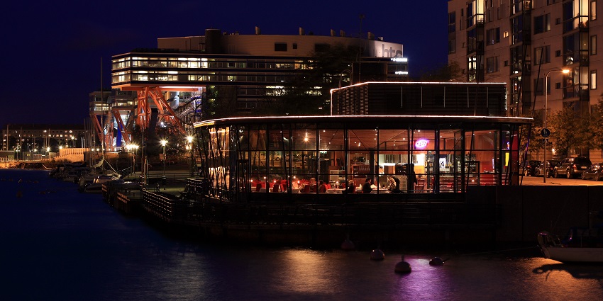 Night view of a restaurant in Finland filled with customers enjoying their food.