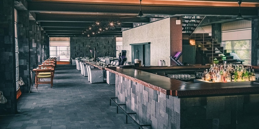 An image showing a modern restaurant interior designed in dark tones with stylish decor.