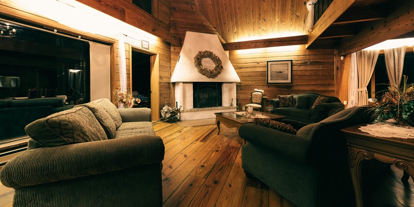Cozy wooden interior of a home with warm lighting, rustic furniture, and natural textures