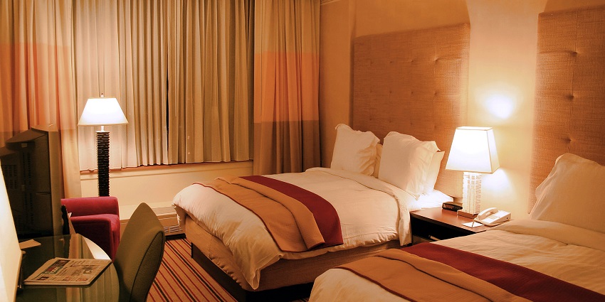A cosy hotel room to stay with neatly made beds, warm lighting, and modern furnishings