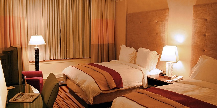A comfortable hotel room featuring well-made beds, soft lighting, and furnishings