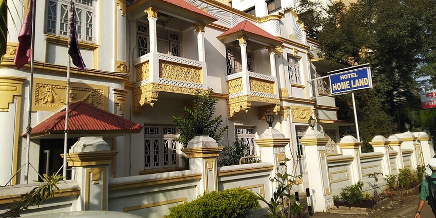 Hotel building with a unique design painted white and yellow with a signboard outside