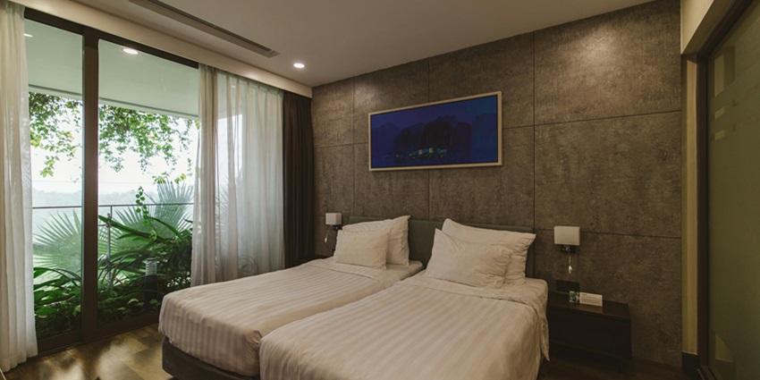 Image of a hotel room with two separate beds, clean sheets and pillow also a table on the side
