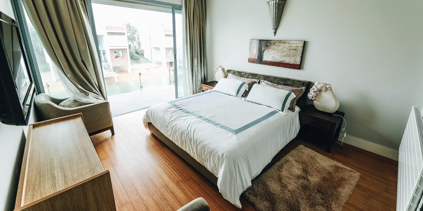 A hotel room in Russia with warm lighting, a neatly made bed, and elegant furnishings.