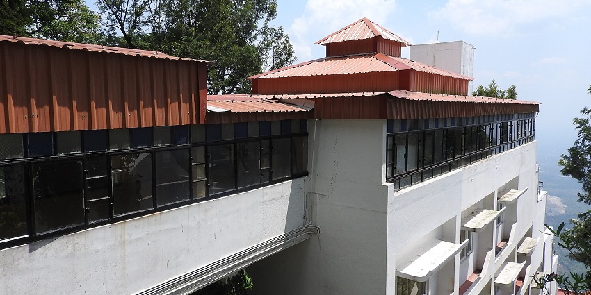 A lavish executive suite room with a view of a river from a glass window.